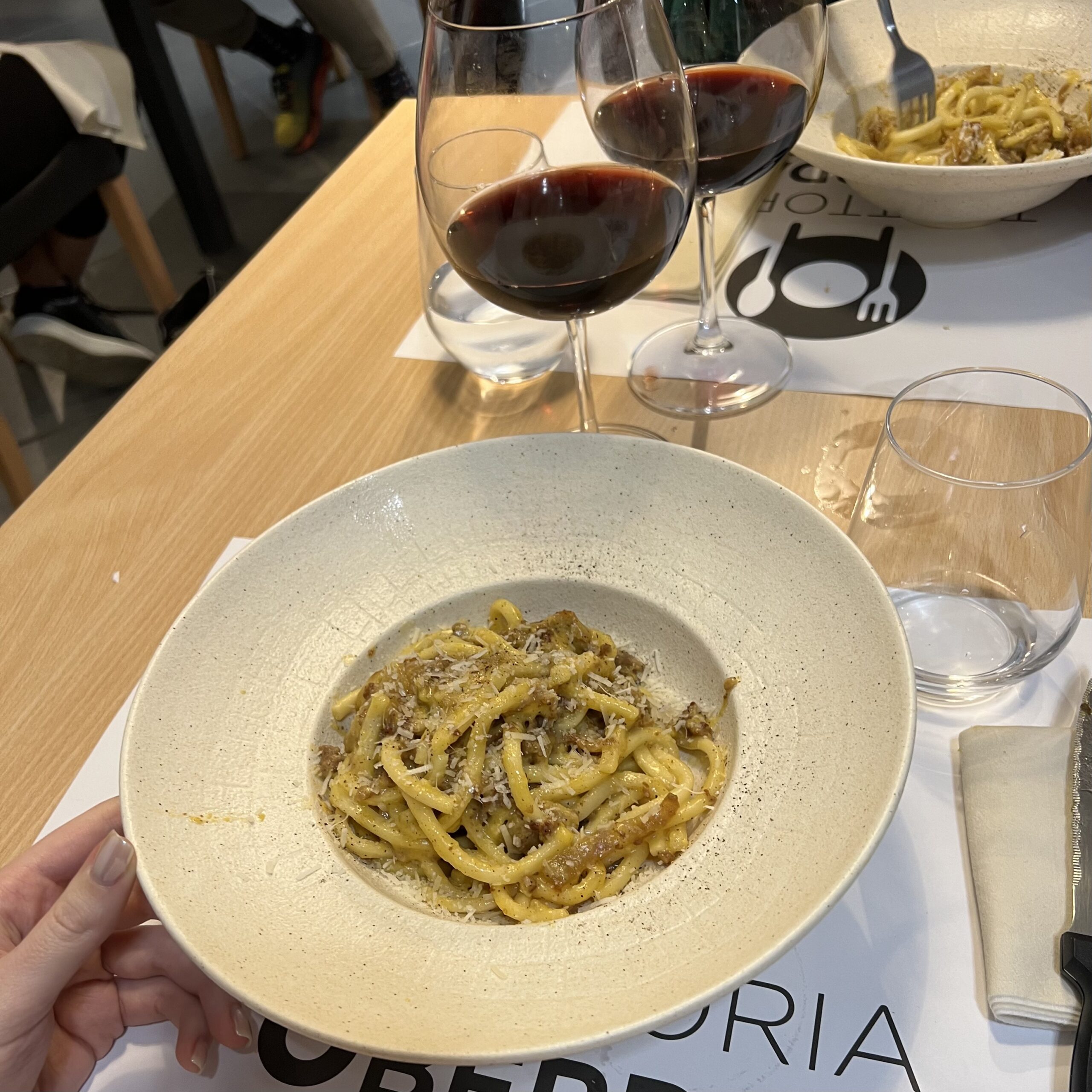 Strascinati di Cascia, carbonara rivisitata in versione umbra con calici di vino rosso